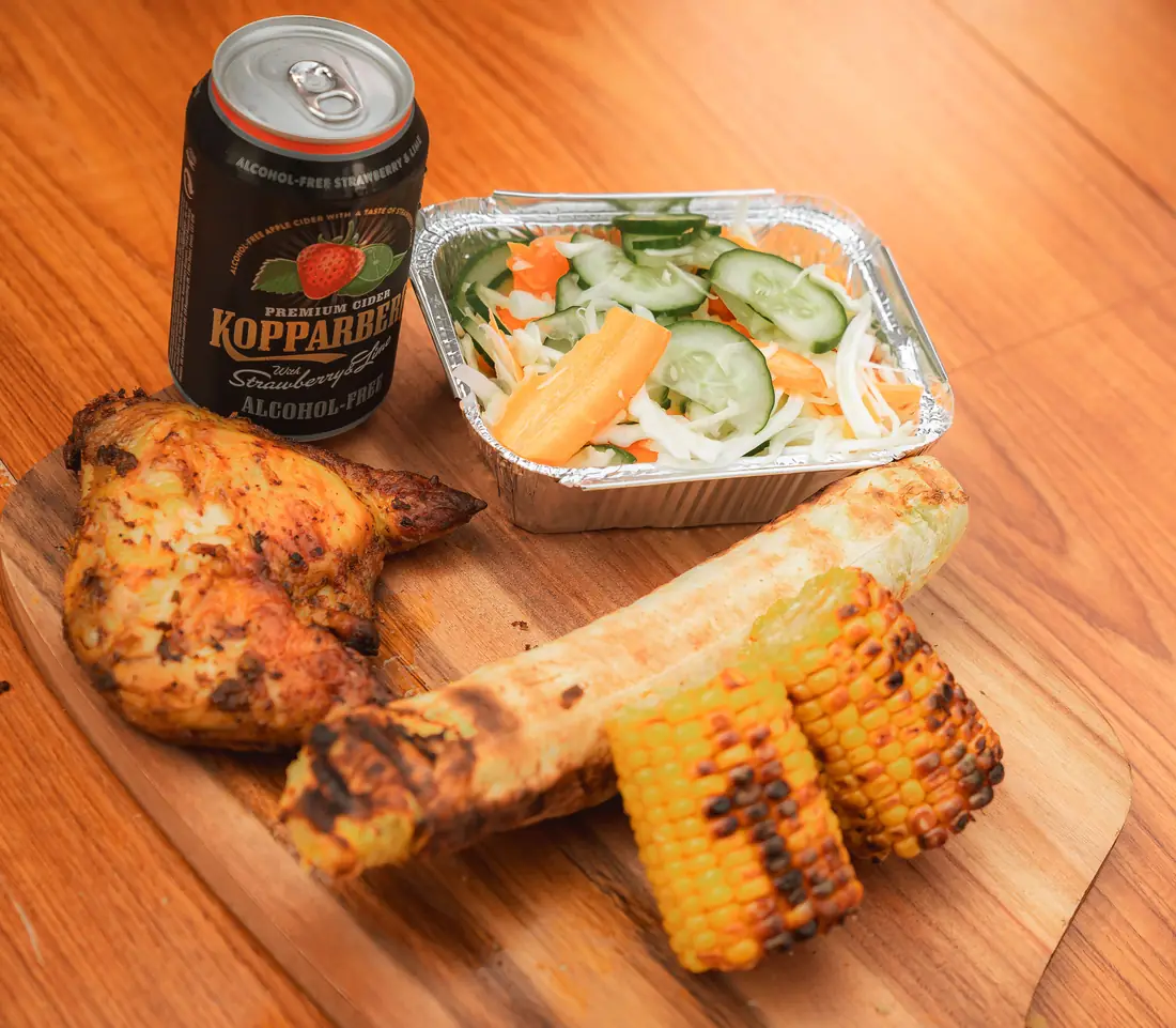 Chicken meal with yam, roasted corn, salad, and alcohol-free Kopparberg