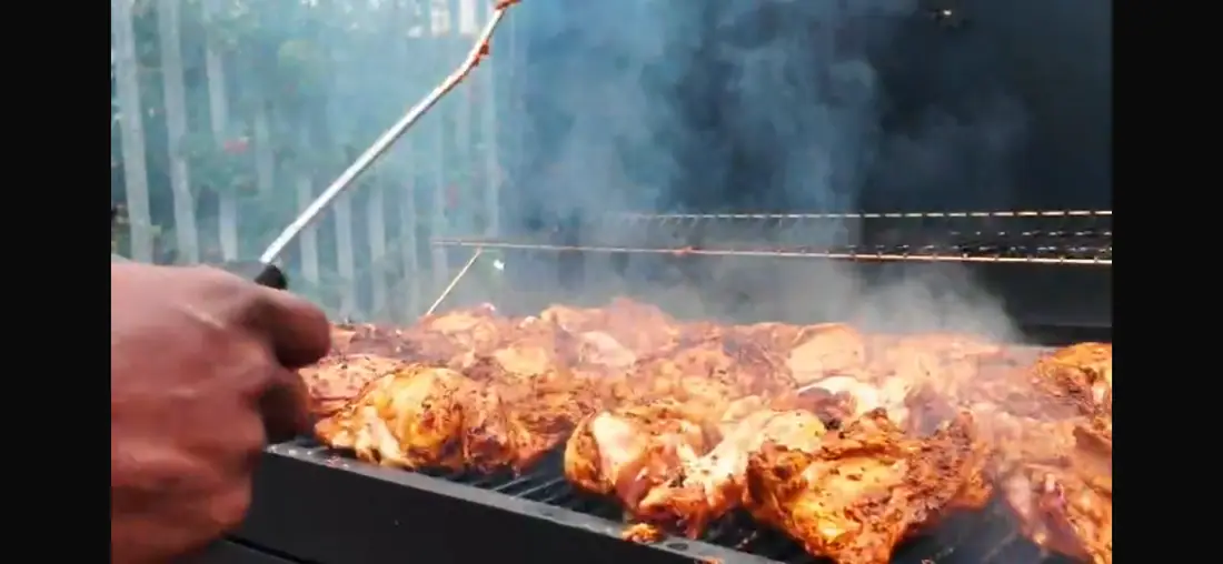 Smoky outdoor grill loaded with chicken